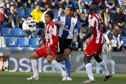 Trezeguet trata de controlar la pelota entre dos rivales del Almería