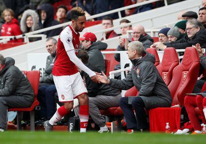El jugador del Arsenal, Pierre-Emerick Aubameyang, saluda a Wenger tras ser sustituido durante un partido frente al Southampton, el 8 de abril de 2018.