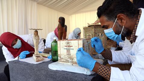 Arqueólogos egipcios estudiando el material descubierto en Saqqara.