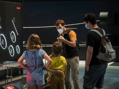 Un mediador de CosmoCaixa explica un experimento a unos visitantes, el lunes en la reapertura del museo.