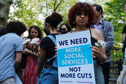 Una manifestante con un cartel que dice "Necesitamos más servicios sociales, no más recortes", este miércoles en Nueva York