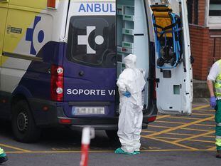 Varios sanitarios protegidos junto a una ambulancia en el Hospital Universitario Cruces, en Bilbao el 19 de marzo. En vídeo, últimos datos sobre el coronavirus en España.
