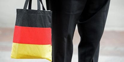 Un hombre lleva una bolsa con los colores de la bandera alemana.