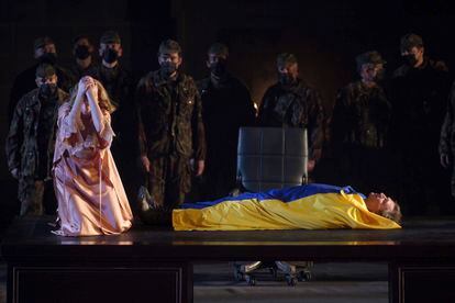 El equipo artístico de 'El ocaso de los dioses' de Wagner envuelve el cadáver de Siegfried en la bandera de Ucrania, como un acto simbólico de homenaje a las víctimas de la guerra en este país, durante la última función de esta ópera en el Teatro Real. 