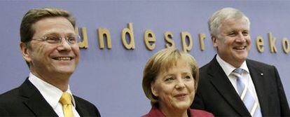 Angela Merkel posa junto a Guido Westerwelle (izquierda) y Horst Seehofer, ayer en Berlín.