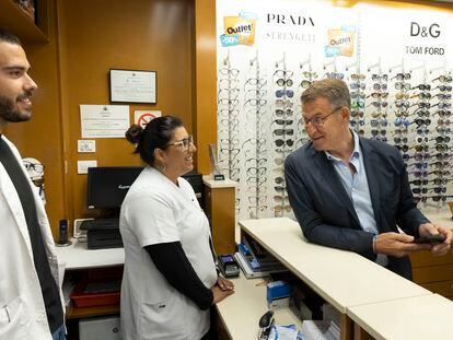 El presidente del Partido Popular, Alberto Núñez Feijóo, conversa con la empleada de una óptica en La Laguna (Tenerife) este lunes.