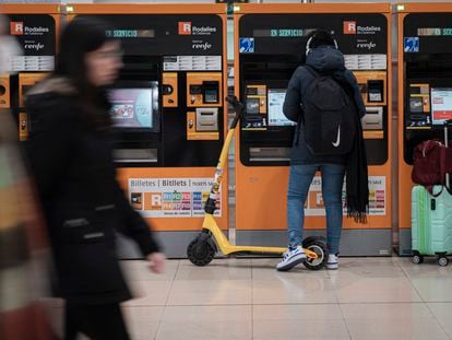Un usuario de patinete eléctrico ante las taquillas de la estación de Sants de Barcelona, la semana pasada.