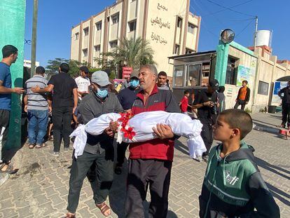 Un padre carga a su hijo tras un ataque de Israel en el sur de Gaza este jueves 26 de octubre.