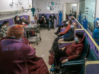 Pacientes con tratamiento intravenoso y de oxígeno en un pasillo de un hospital en Shanghái, el viernes.