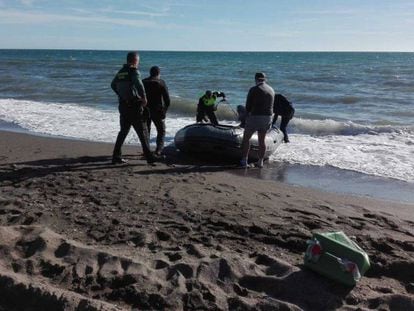 Agentes de la Guardia Civil y la Policía Local, con la patera que este sábado ha llegado a Vélez-Málaga.