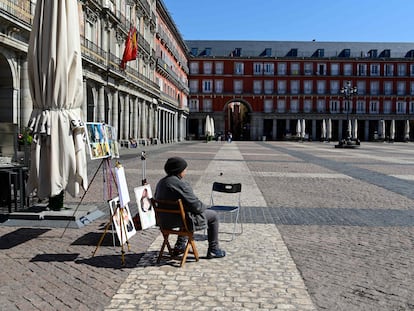 Un caricaturista espera a que llegue algún cliente en la Plaza Mayor de Madrid.