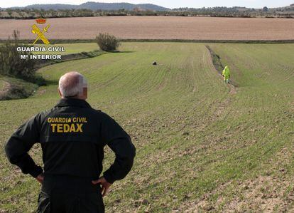 Un agente de los Tedax observa el campo donde este martes cayó el objeto espacial en el municipio de Mula (Murcia).