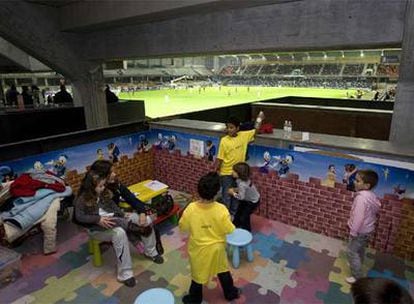 Un grupo de niños juegan en la guardería del estadio de Pasarón, durante el partido de ayer.