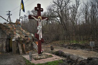 Señal de peligro de minas junto a un crucifijo en un control militar a la entrada de la localidad de Shevchenkove (región de Járkov).