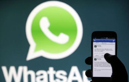 Un usuario de móvil frente al logo de WhatsApp