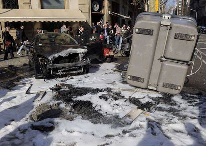 Un coche y un contenedor de basura dañados después de las protestas, en Barcelona.