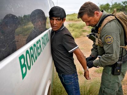 Un agente de la Patrulla Fronteriza estadounidense quita las esposas a un migrante detenido para que éste sea transportado, el pasado 8 de septiembre, cerca de Sasabe, Arizona (EE UU).