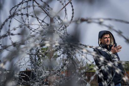Un refugiado habla a los periodistas tras las concertinas en el lado serbio de la frontera sur húngara con Serbia, cerca de Tompa, Hungría.