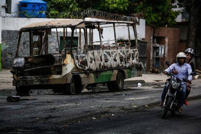 Un autobús incendiado durante los disturbios de este domingo.