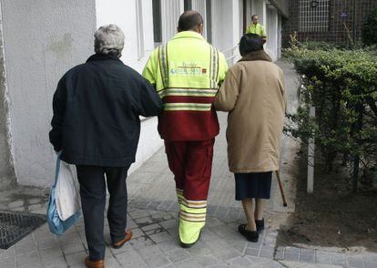 Un asistente acompa&ntilde;a a dos pacientes de di&aacute;lisis en Madrid.