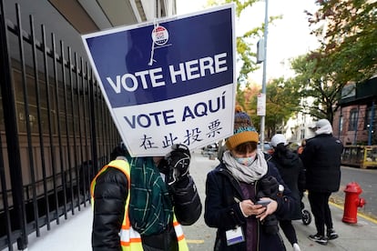 Un voluntario con un cartel escrito en inglés, español y chino, en noviembre en las elecciones locales de Nueva York.