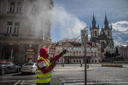 Un trabajador limpia una señal de tráfico en Praga (República Checa) el 1 de mayo