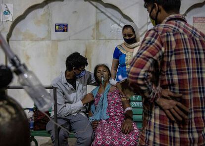El recrudecimiento de la situación en la India ha sido atribuido a una mutación doble así como a certámenes religiosos y deportivos con asistencia numerosa. En la imagen, una mujer recibe oxígeno de forma gratuita en un templo de Ghaziabad, el sábado.