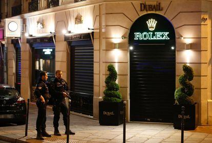 Dos agentes de la policía se paran frente a una tienda cerca de los Campos Elíseos en París, después del tiroteo donde ha muerto un policía y otro ha resultado herido.