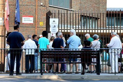Varias personas hacen cola para entrar a votar en el colegio Escuelas Aguirre, este domingo en Madrid.
