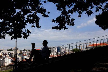 Un hombre lee en el jardín del Torel (Lisboa).