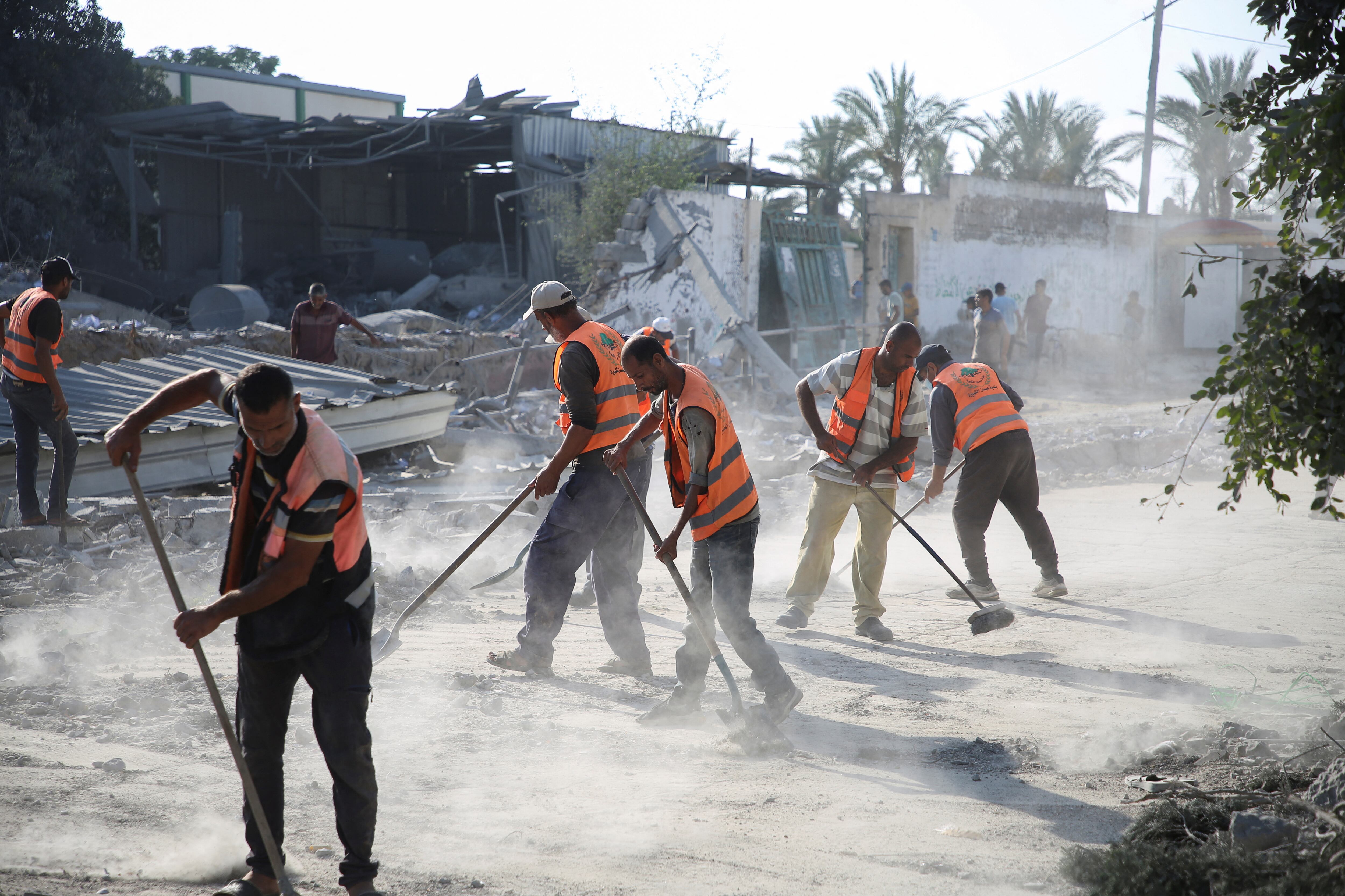 Workers remove debris to clean a road, following an Israeli strike on a school sheltering displaced people, amid the Israel-Hamas conflict, in Khan Younis, in the southern Gaza Strip, June 27, 2024. REUTERS/Hatem Khaled