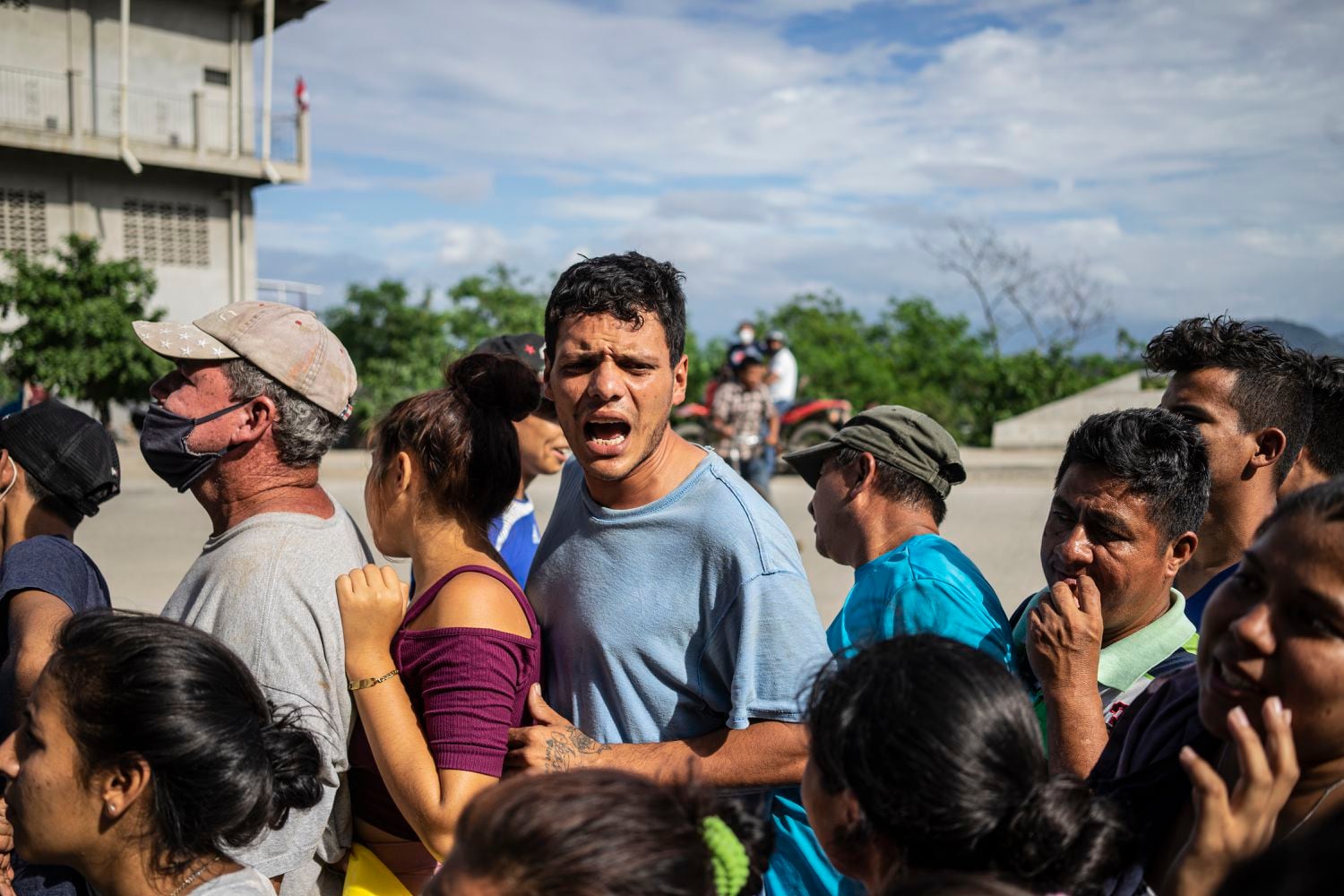 Damnificados por la tormenta forman en una fila para recibir comida. 