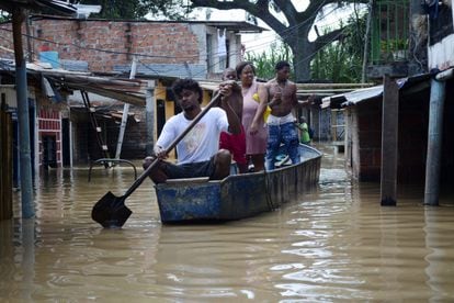 La gente recorre las calles inundadas del barrio Playa Renaciente, después de que el río Cauca se desbordara debido a las fuertes lluvias.