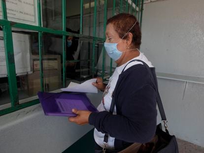 Una mujer de la tercera edad realiza un trámite en una clínica del IMSS en Querétaro.