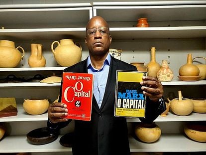 Camargo poses with some of the books that he tried to purge from the institution's collection in another photo on his Twitter.