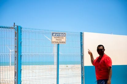 João do Cumbe muestra un cartel con un aviso de propiedad privada en las dunas donde se instalaron los aerogeneradores. 