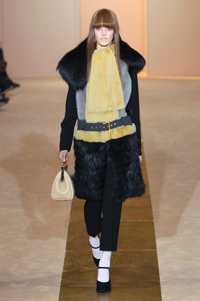 Marni ha diseñado este abrigo negro de piel y pelo largo con bufanda en tono amarillo para su colección de invierno.