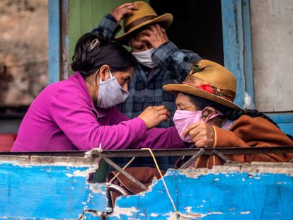 Una familia en Pamplona Alta, a las afueras de Lima (Perú), se prepara para salir con mascarillas.