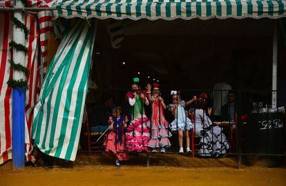 TOPSHOT - Little girls wearing traditional Sevillian dresses play during the "Feria de Abril" (April Fair) in Sevilla on April 30, 2017. 
The fair dates back to 1847 when it was originally organized as a livestock fair but has turned into a week of flamenco dancing, music and bullfighting.  / AFP PHOTO / CRISTINA QUICLER