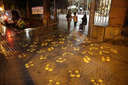 Operaris de neteja esborrant pintades al terra que representen trepitjades i llaços grocs en suport als líders independentistes, al col·legi Ramon Llull de Barcelona.