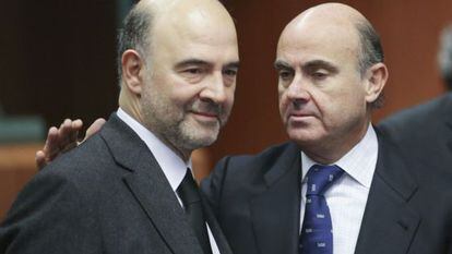 El ministro espa&ntilde;ol de Econom&iacute;a, Luis de Guindos, saluda al comisario europeo de Asuntos Econ&oacute;micos, Pierre Moscovici.