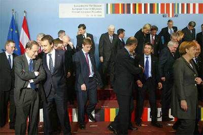 A la izquierda, Javier Solana escucha al presidente Zapatero mientras los líderes europeos se sitúan para la foto de familia de la cumbre de Bruselas.