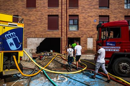 Bomberos de la Junta de Castilla-La Mancha sacan el agua acumulada en los garajes de un edificio de Casarrubios del Monte, Toledo.