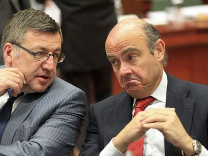 El ministro de Economía del Gobierno español, Luis de Guindos (derecha), conversa con el titular de Finanzas belga, Steven Vanackere