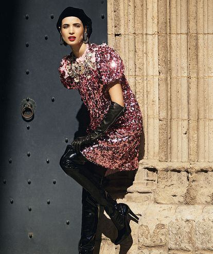 Vestido de lentejuelas con pedrería en el cuello de Dolce & Gabbana
(c. p. v.), boina de Giorgio Armani (1.550 €), pendientes de H&M (7,99 €), guantes de Chanel (1.060 €) y botas de charol de Unisa (149 €).
