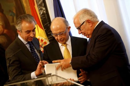 Montoro recibe el informe de manos de Lagares, derecha, junto con el Secretario de Estado Miguel Ferre.