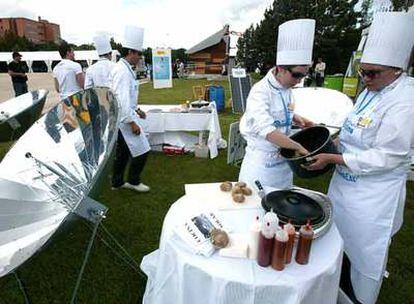 Alumnos de la Escuela de Hostelería de Madrid preparan comidas en los hornos y cocinas solares del puesto de Movimiento Clima.