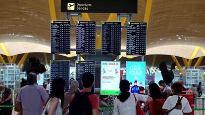 Pasajeros comprueban información sobre su vuelo en la terminal 4 del aeropuerto Adolfo Suárez-Barajas en Madrid, este domingo.