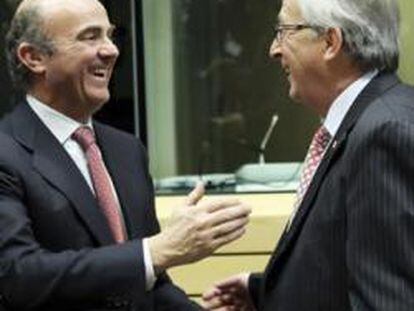 El ministro de Economía y Competitividad, Luis de Guindos, conversa con el presidente del Eurogrupo, Jean-Claude Juncker, y con el ministro de Finanzas galo, François Baroin