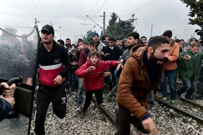 Los migrantes corren después de romper el bloqueo de la policía griega hacia la frontera de Macedonia, cerca del pueblo griego de Idomeni.